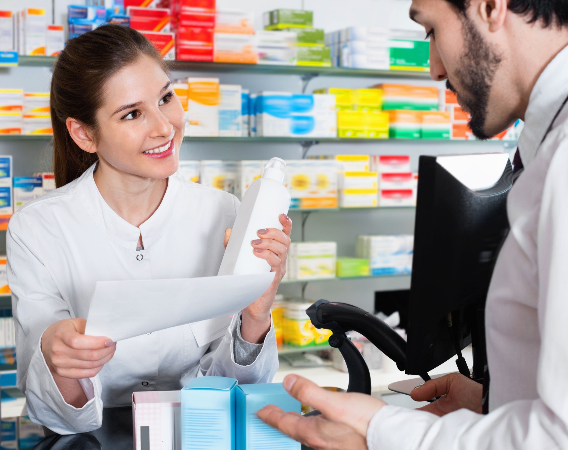 Farmacéutico de mujer recomienda medicina para cliente de hombre en el Boticario.